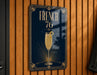 A sign with the text "FRENCH 76" and an illustration of a champagne glass with a lemon slice.