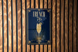 A poster with the text "FRENCH 76" and an illustration of a champagne glass is displayed on a wooden wall.