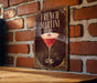 A framed poster of a French martini is displayed on a brick wall.
