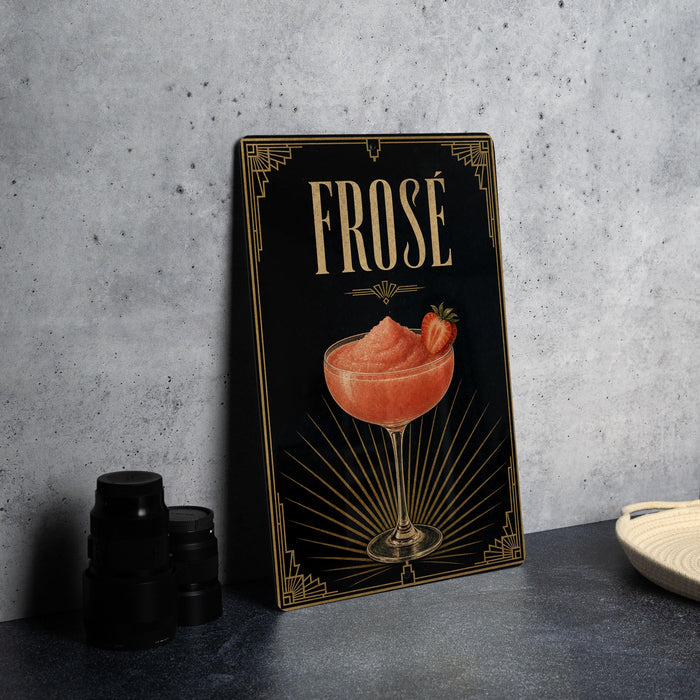 a framed illustration of a cocktail glass with a strawberry garnish, placed on a table next to a stack of black containers.