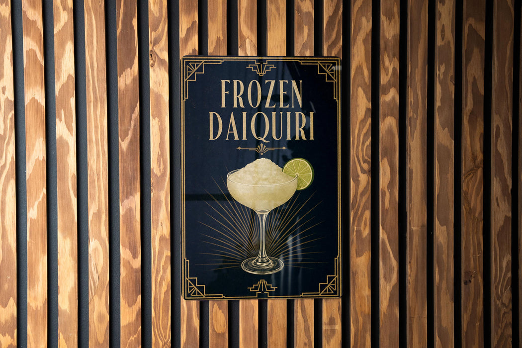 A poster advertising a frozen daiquiri, featuring a glass of the cocktail with a lime wedge.
