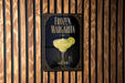 A sign for a frozen margarita is displayed on a wooden wall.