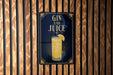 A sign with the text "GIN AND JUICE" and an illustration of a cocktail glass with a lemon slice.