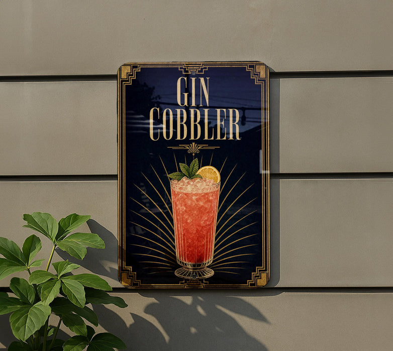 A sign for a gin cobler cocktail is displayed on a wall, with a plant visible to the left.