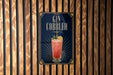 A poster advertising a gin cobler is displayed on a wooden wall.