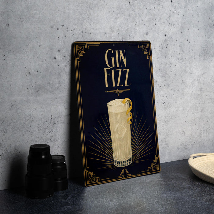 A decorative sign for a gin fizz cocktail, featuring an illustration of a tall glass filled with a yellow liquid and a lemon slice.