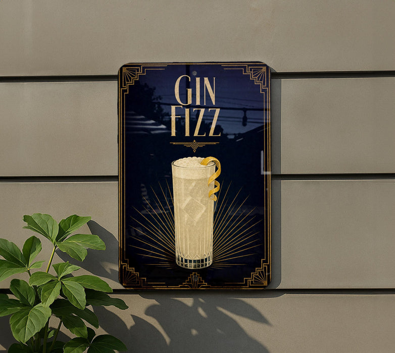 A sign for a gin fizz cocktail is displayed on a wall, with a plant visible to the left.