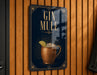 A sign with the text "GIN MULE" and an illustration of a copper mug with a lime slice, set against a dark blue background with decorative elements.