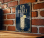 A sign for "Gin Richey" is displayed on a brick wall, featuring an illustration of a gin and tonic drink with a lemon slice.