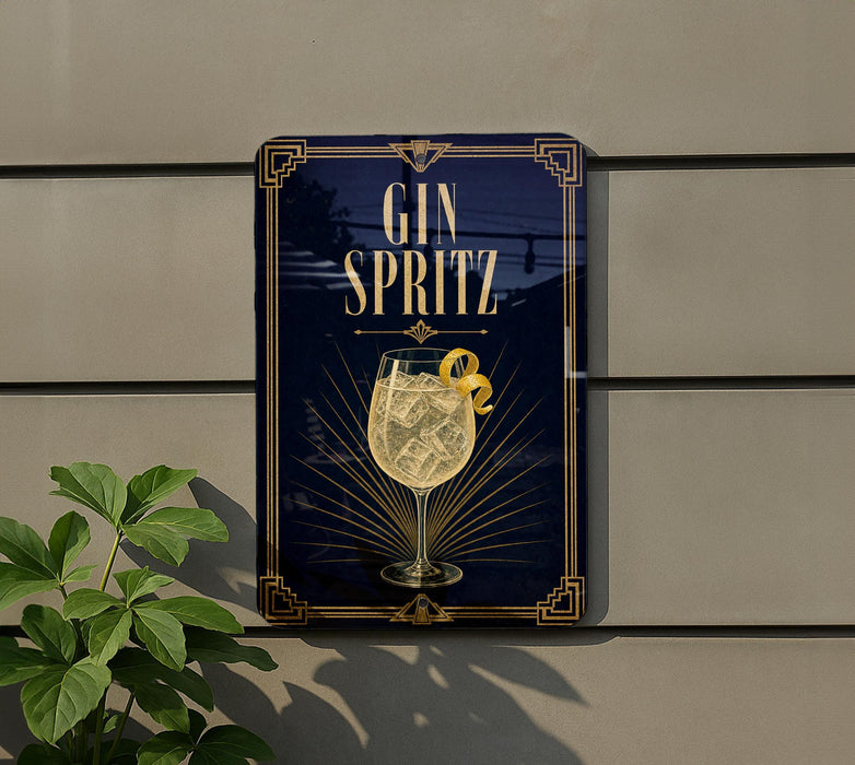 A sign for a gin cocktail called "Spritz" is displayed on a wall, with a glass of the cocktail and a lemon peel as the central elements.