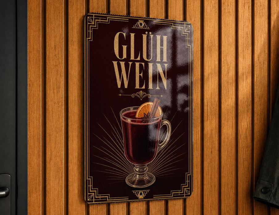 A metallic sign with a dark background and gold accents, featuring an illustration of a glass of what appears to be a warm beverage, possibly a hot chocolate or mulled wine, garnished with a slice of orange.