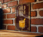 A sign with the text "GOLD RUSH" and an illustration of a cocktail is displayed on a brick wall.