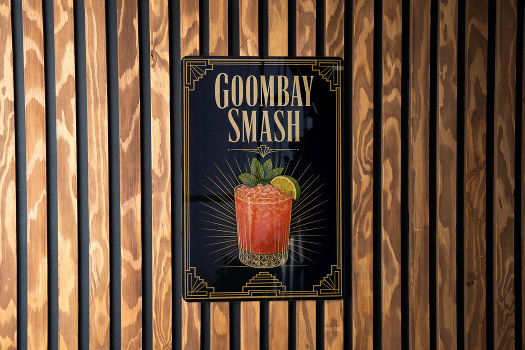 A sign for Goombay Smash cocktail is displayed on a wooden wall.