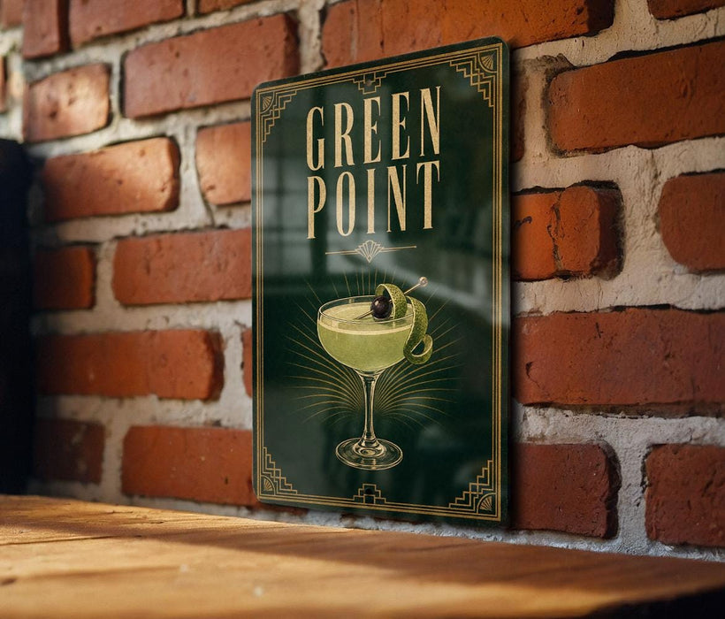 A sign for "Green Point" cocktail is displayed on a brick wall, featuring an illustration of a cocktail glass with a lemon twist.