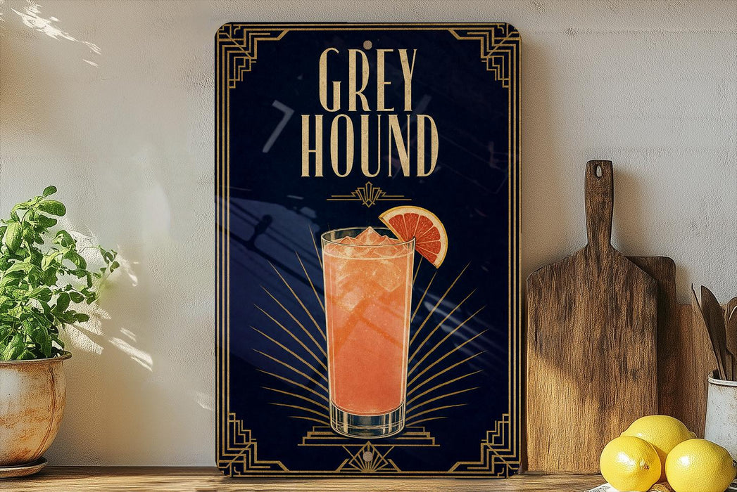 A framed advertisement for a cocktail called "Greyhound" featuring a glass of orange drink with a slice of lemon.