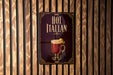A sign for "Hot Italian" is displayed on a wooden wall, featuring an illustration of a hot beverage with a lemon twist.