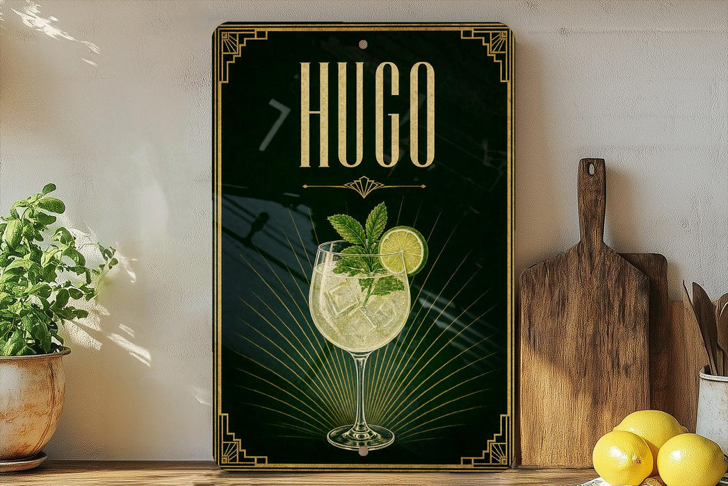 A decorative sign for a drink called "HUGO" featuring a glass of lemonade with a mint garnish, placed on a wooden surface next to a wooden cutting board and a potted plant.