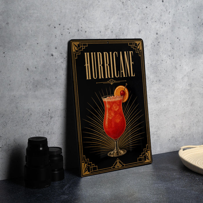 A framed illustration of a cocktail with a garnish, accompanied by the word "HURRICANE" on a black background with gold accents.