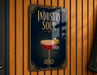A sign for "Industry Sour" cocktail, featuring an illustration of a glass with a red drink and lemon slices.