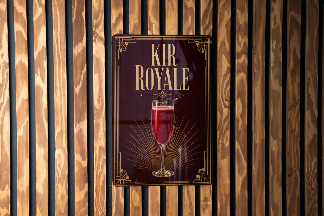 a sign for "Kir Royale", which is a cocktail, hanging on a wooden wall.