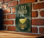 A sign with the text "LAST WORD" and an illustration of a cocktail glass is displayed on a brick wall.