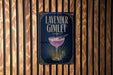 A sign for a lavender gimlet cocktail is displayed on a wooden wall.