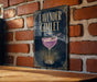 A sign for a lavender gimlet cocktail is displayed on a brick wall.