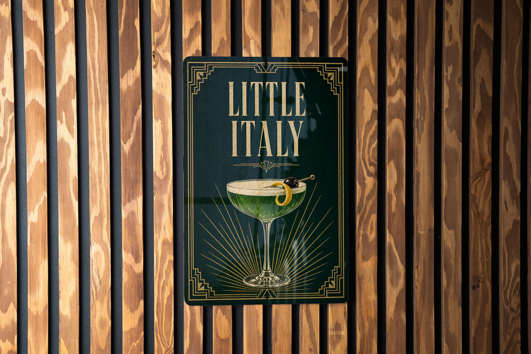 A sign for "Little Italy" hanging on a wooden wall.