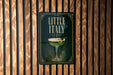 A sign for "Little Italy" hanging on a wooden wall.
