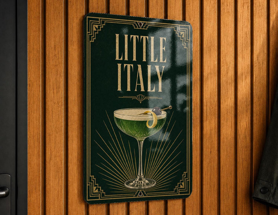 A sign that reads "Little Italy" with an illustration of a cocktail on a wooden wall.