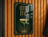 A sign that reads "Little Italy" with an illustration of a cocktail on a wooden wall.