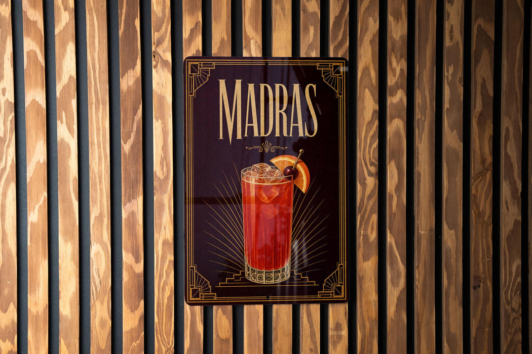 A sign for Madras cocktails is displayed on a wooden wall.