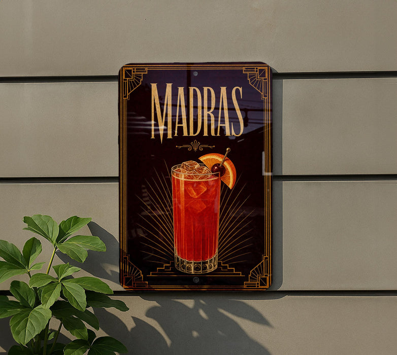 A decorative sign for Madras cocktails is displayed on a wall, featuring an illustration of a cocktail glass with a slice of orange.