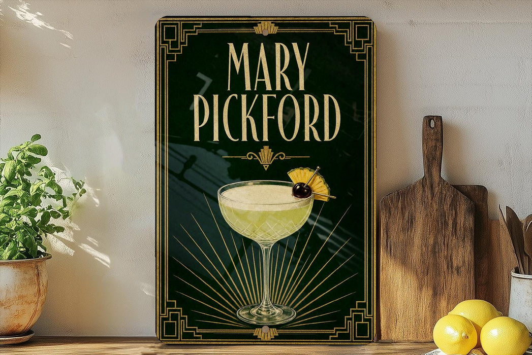 A framed poster of a cocktail called "Mary Pickford" is displayed on a wall, with a wooden cutting board and a potted plant to the side.