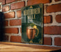 A sign for a Mediterranean mule cocktail is displayed on a brick wall.
