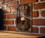 A decorative metal sign with the text "MEXICAN COFFEE" and an illustration of a coffee drink is displayed on a brick wall.