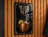 A sign for "Mezcal Mule" is displayed on a wooden wall, featuring an illustration of a copper mug with a lime slice.