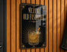 A sign that reads "MEZCAL OLD FASHIONED" with an illustration of a cocktail on a wooden wall.