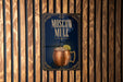 A poster advertising Moscow Mule, a Moscow-style alcoholic cocktail, is displayed on a wooden wall.