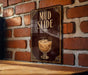 A sign with the text "MUD SLIDE" is displayed on a brick wall, with an illustration of a cocktail or drink in the center.
