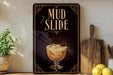 a sign for a mud slide cocktail, with a glass of the drink prominently displayed.