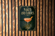 A sign that reads "Naked and Famous" with an illustration of a cocktail on a green background.