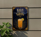 a sign for a drink called "Navy Grog" with a glass illustration and a lemon slice.