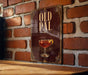 a sign with the word "OLD PAL" on it, which is displayed on a brick wall.