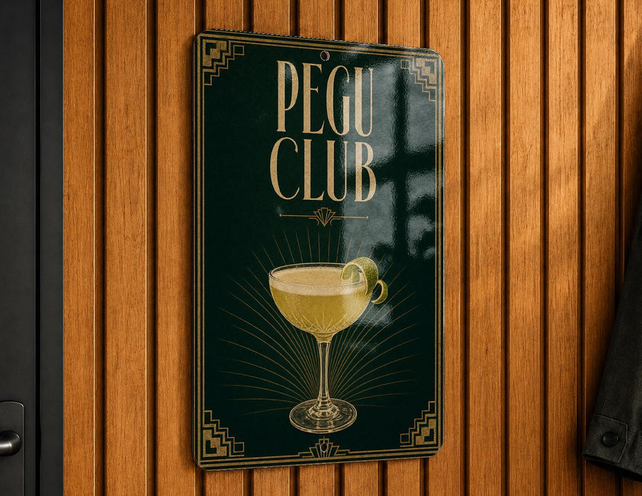 A sign for the "Pegu Club" featuring an illustration of a cocktail glass with a lemon on the side.