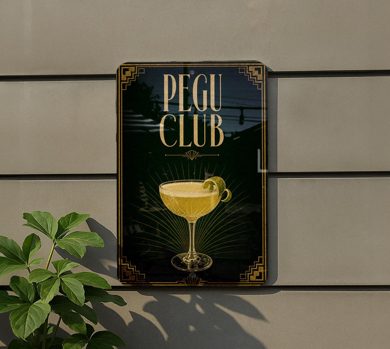 A sign for the "Pegu Club" featuring a glass of yellow liquid, likely a cocktail, with a decorative design.