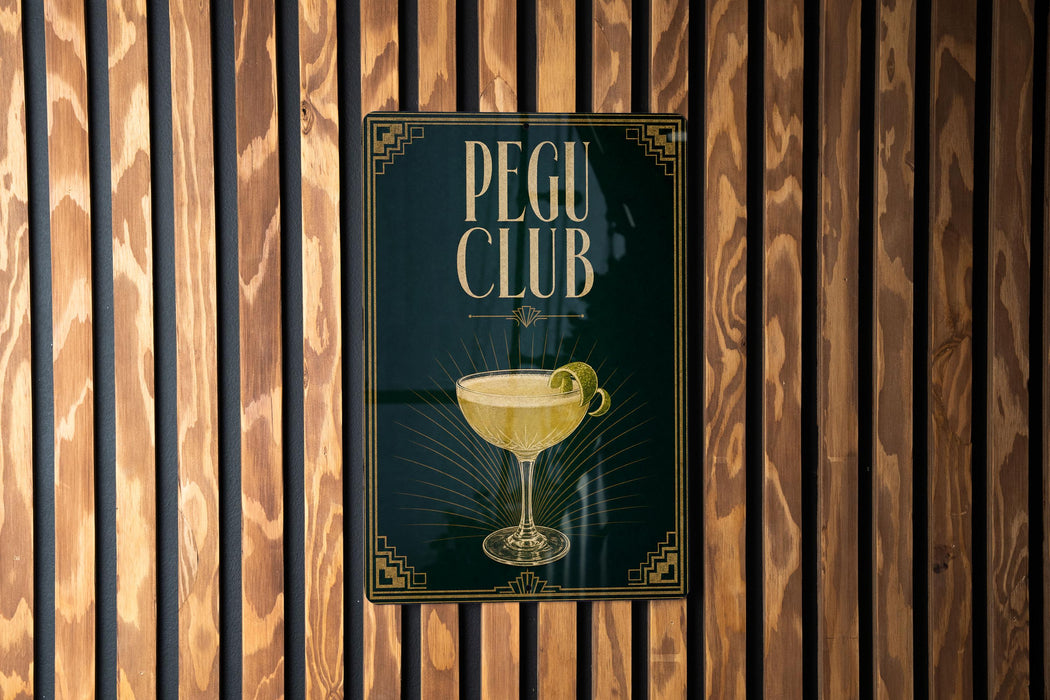 A sign for the "Pegu Club" is displayed on a wooden wall.