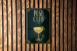 A sign for the "Pegu Club" is displayed on a wooden wall.