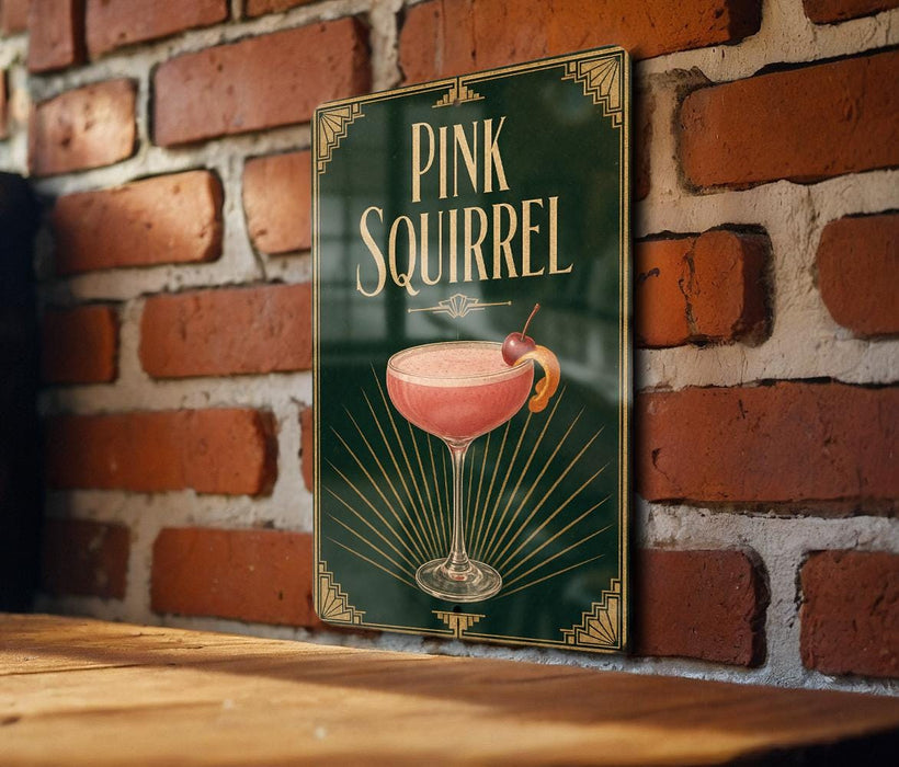 A sign for a pink squirrel cocktail is displayed on a brick wall.