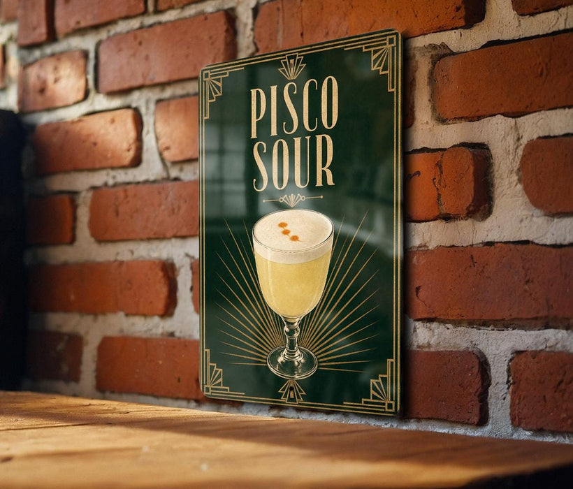 A sign for a drink called "Pisco Sour" is displayed on a brick wall.
